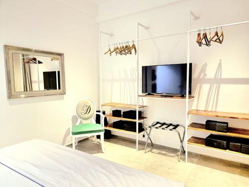尼甘布Ocean view luxury apartments的一间白色卧室,配有电视和椅子