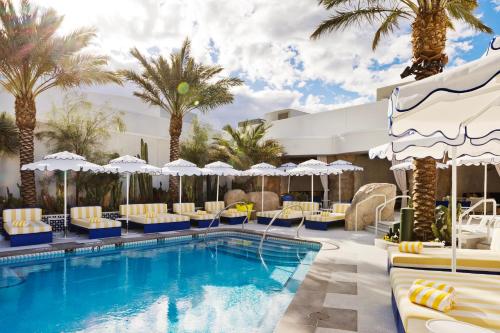 拉斯维加斯Fontainebleau Las Vegas的度假酒店的游泳池配有椅子和遮阳伞