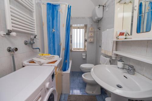 米诺利Casa Maria Vittoria的白色的浴室设有水槽和卫生间。