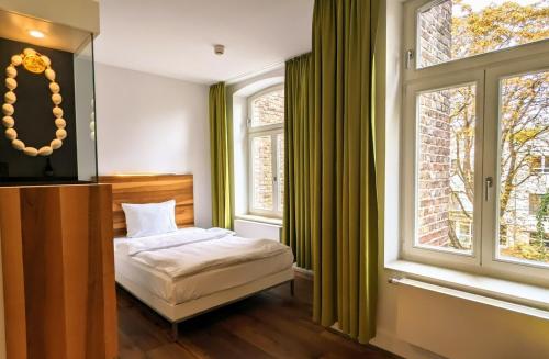 科隆豪博圣约瑟夫酒店的一间卧室设有一张床和一个大窗户