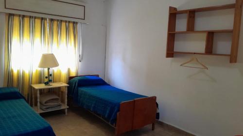 GualeguaychúMilli的客房设有两张床、一盏灯和一扇窗户。