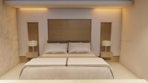 恩塞纳达港Jules & Laurent Hotel Contemporaneo的一间卧室配有一张带两盏灯的大型白色床。