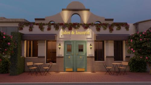 恩塞纳达港Jules & Laurent Hotel Contemporaneo的前方有蓝色门和椅子的建筑