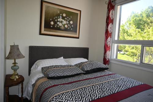尼亚加拉瀑布Centennial Suite的卧室配有带枕头的床铺和窗户。