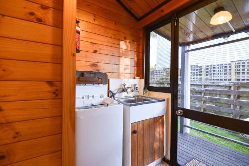罗托鲁瓦Cooper's Lakeside Cabin的厨房配有水槽和洗衣机