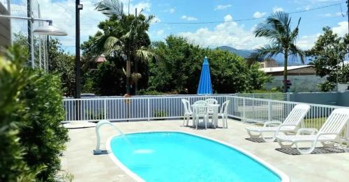 帕罗卡Recanto Munik的庭院设有游泳池、椅子和桌子。