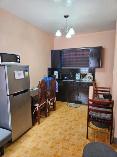八打雁Mel's Place 2BR Apartment Unit2 in Batangas City的厨房配有冰箱和桌椅