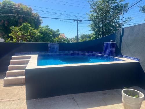 库亚巴Suíte Príncipe Charles Ceres0021的一个带蓝色墙壁和楼梯的游泳池