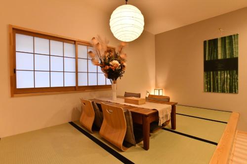 大阪FL House 浪花町的一间设有桌子和花瓶的用餐室