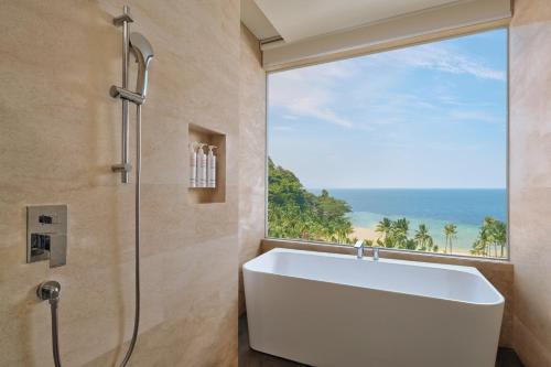 LampungLampung Marriott Resort & Spa的带浴缸的浴室和大窗户