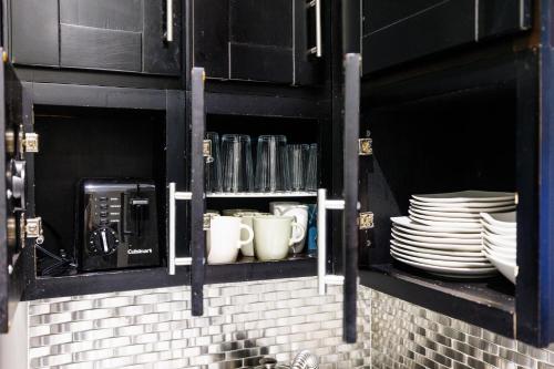 纽约Park Side Living, City Style的黑橱柜,带盘子和杯子,咖啡杯