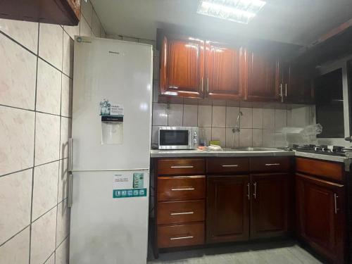 杜阿拉Danin Real-estates的厨房配有白色冰箱和木制橱柜。