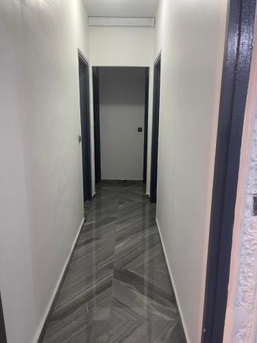 杜阿拉Danin Real-estates的走廊设有白色墙壁和木地板