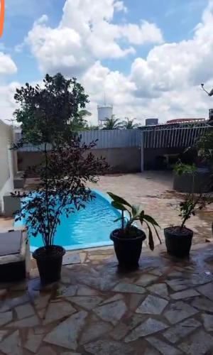 阿纳波利斯Espaço Lazer Ramos的一座拥有两株盆栽植物的院子内的游泳池