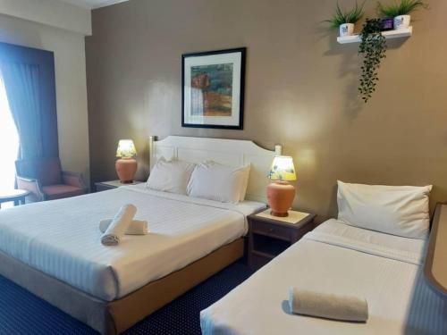 丹绒武雅17 Jazz sweet beachfront resort的酒店客房设有两张床和两盏灯。