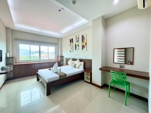 科隆Sunburn Suites and Rooftop Bar的一间卧室配有一张床和一把绿色椅子
