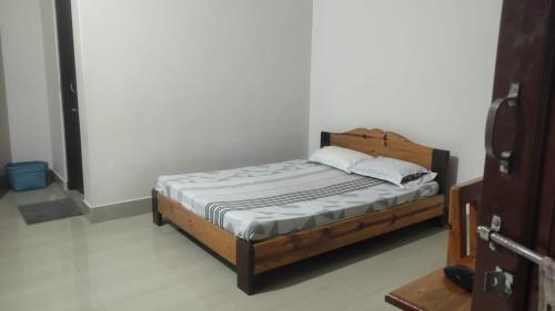 迪马普尔Vosu Homestay的一间卧室,卧室内配有一张木床