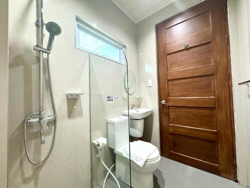科隆Sunburn Suites and Rooftop Bar的带淋浴和卫生间的浴室以及玻璃门。