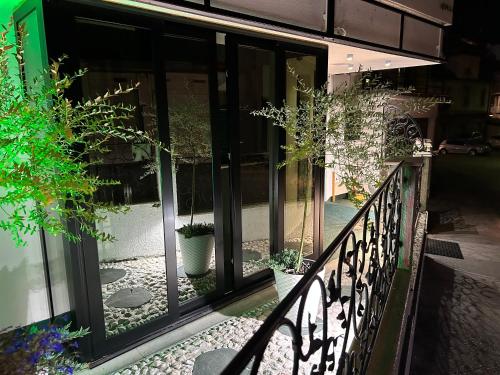 萨拉热窝Halvat Guesthouse的阳台设有玻璃门和盆栽植物