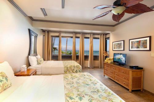 卡哈纳Oceanfront corner unit w/ ac! sk215- Sullivan的一间卧室配有两张床和吊扇