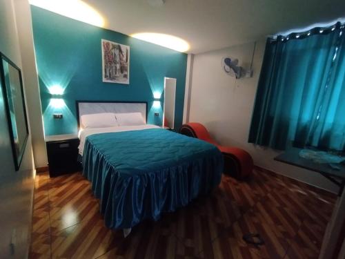 利马Hostal El Pilar的一间卧室设有一张床和蓝色的墙壁