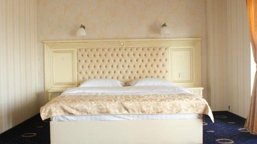 Valea LupuluiAmbasador的一间卧室配有一张带白色床头板的大床