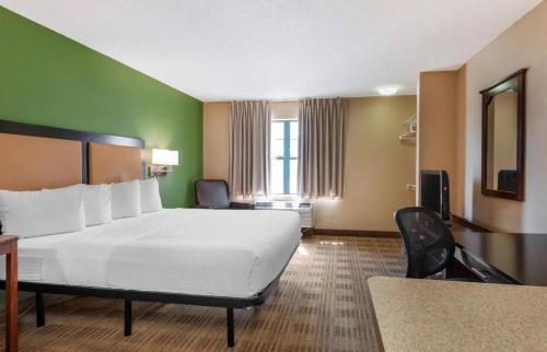 拉米拉达Relax Suites Extended Stay - La Mirada的酒店客房设有一张大床和一张书桌。