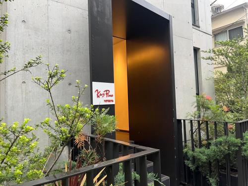 东京Ken's Place四谷的一座带橙色门的建筑的入口