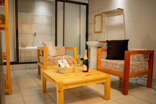 马塞卢Thabeng Hotel & Restaurant的客厅配有桌子、椅子和浴缸