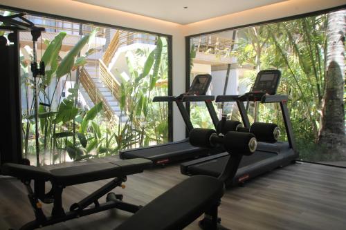 爱妮岛ANGKLA Beach Club & Boutique Resort的窗户前有三个跑步机的健身房