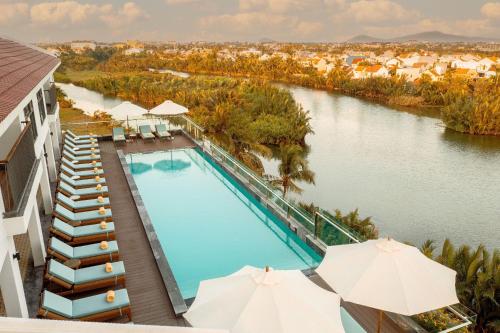 会安Little Oasis - An Eco Friendly Hotel & Spa的享有带遮阳伞的游泳池的顶部景致