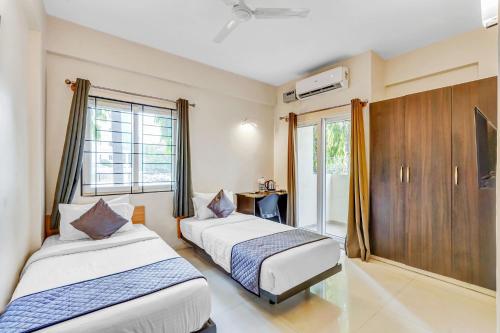 班加罗尔UPAR Hotels near Bagmane Tech Park的酒店客房设有两张床和电视。