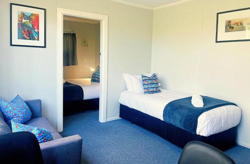 KurowKurow Motel的一间卧室配有一张床、一把椅子和镜子
