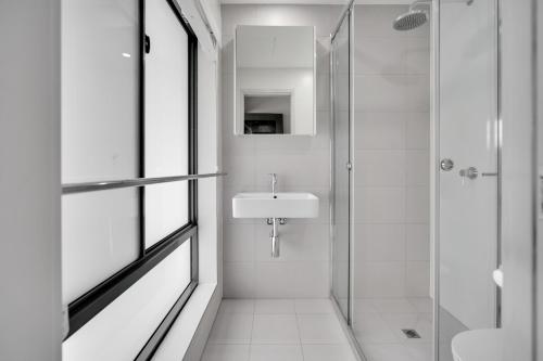 汤斯维尔Belmoral Corporate Suites的白色的浴室设有水槽和淋浴。