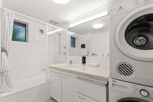 布里斯班杜旺别墅酒店的白色的浴室设有水槽和洗衣机。