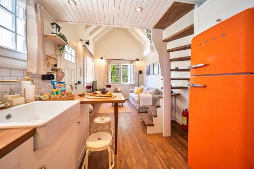 戈西克The Box House & Charming Private Tiny House & Pool的橙色和白色的厨房设有水槽和客厅。
