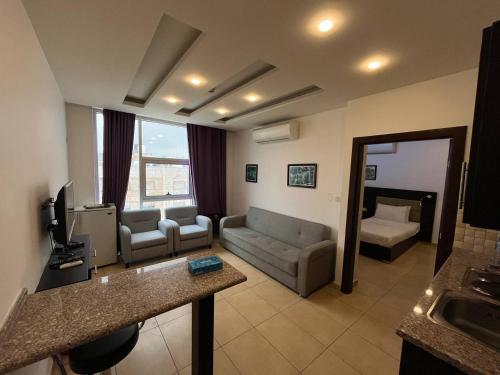 Umm Uthainah7 Days Hotel的带沙发和电视的客厅以及客厅。