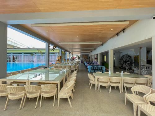 三宝颜LM METRO HOTEL的一个带桌椅的自助餐厅和一个游泳池