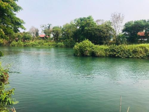 Muang KhôngThe Smiling Lao的一条有绿水和树木的河流