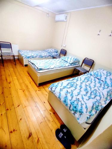 连科兰Hostel ucuz的铺有木地板的客房内的三张床