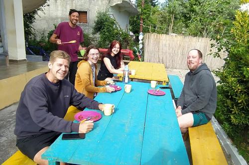 伏罗拉Pinegroove Hostel Vlora的一群人坐在一张蓝色桌子旁