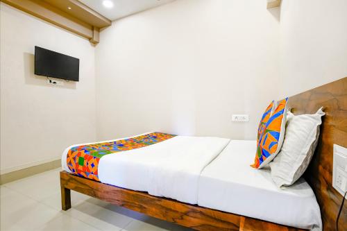 BhathaFabHotel Royal Paradise的卧室配有一张床铺,墙上配有电视