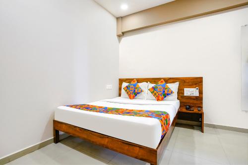 BhathaFabHotel Royal Paradise的一间卧室配有一张带木制床头板的床
