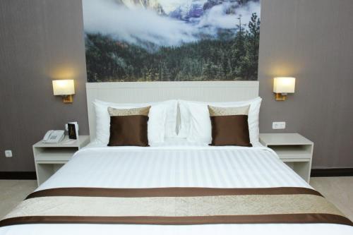 TobadiHorison abepura的一间卧室配有一张带2个床头柜的大型白色床