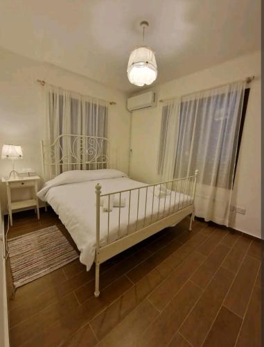 普拉特斯Butterfly Home的卧室配有白色的床和吊灯。