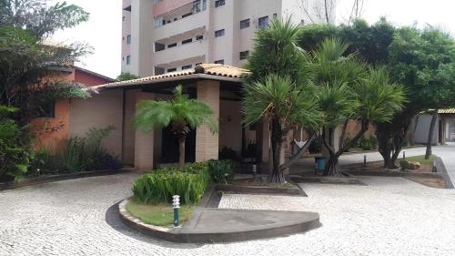 福塔莱萨Hotel Navegantes Beach的一座楼前有棕榈树的房子