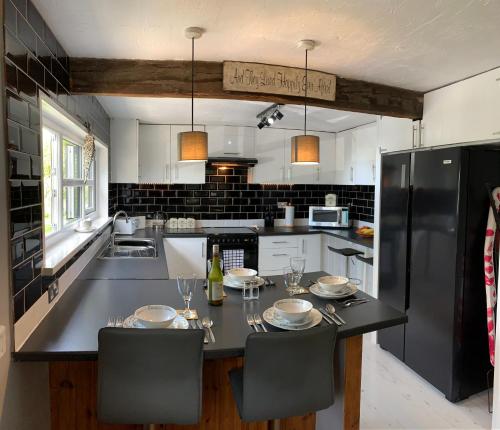 卡纳芬The Lodge@Tyddyn Ucha的厨房配有桌椅和黑冰箱。