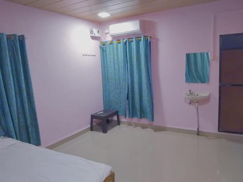 阿里巴格MADHULI COTTAGE的一间医院间,配有床和水槽