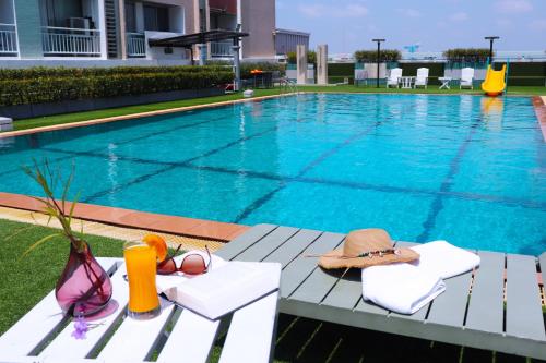 曼谷Evergreen Place Siam by UHG的一个带帽子和太阳镜的游泳池