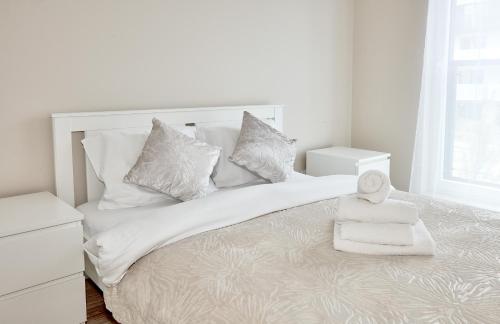 波兹南Poznań Airport Comfort Apartment的白色卧室配有带白色床单和枕头的床